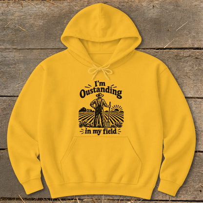 Yellow hoodie with a graphic of a farmer in a field, text says "I'm Oustanding in my field".