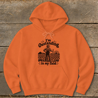 Orange hoodie with black text and graphic: "I'm Oustanding in my field."