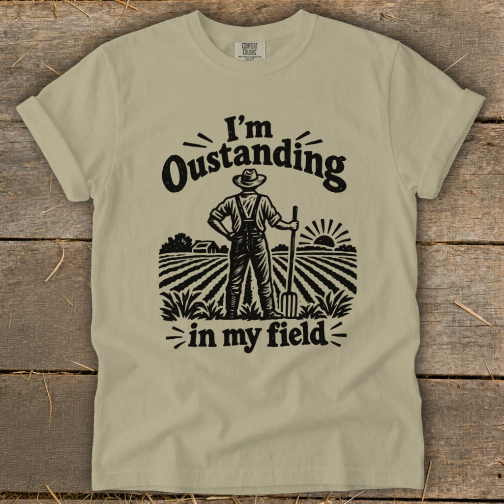 T-shirt with text "I'm Oustanding in my field" and farmer illustration.