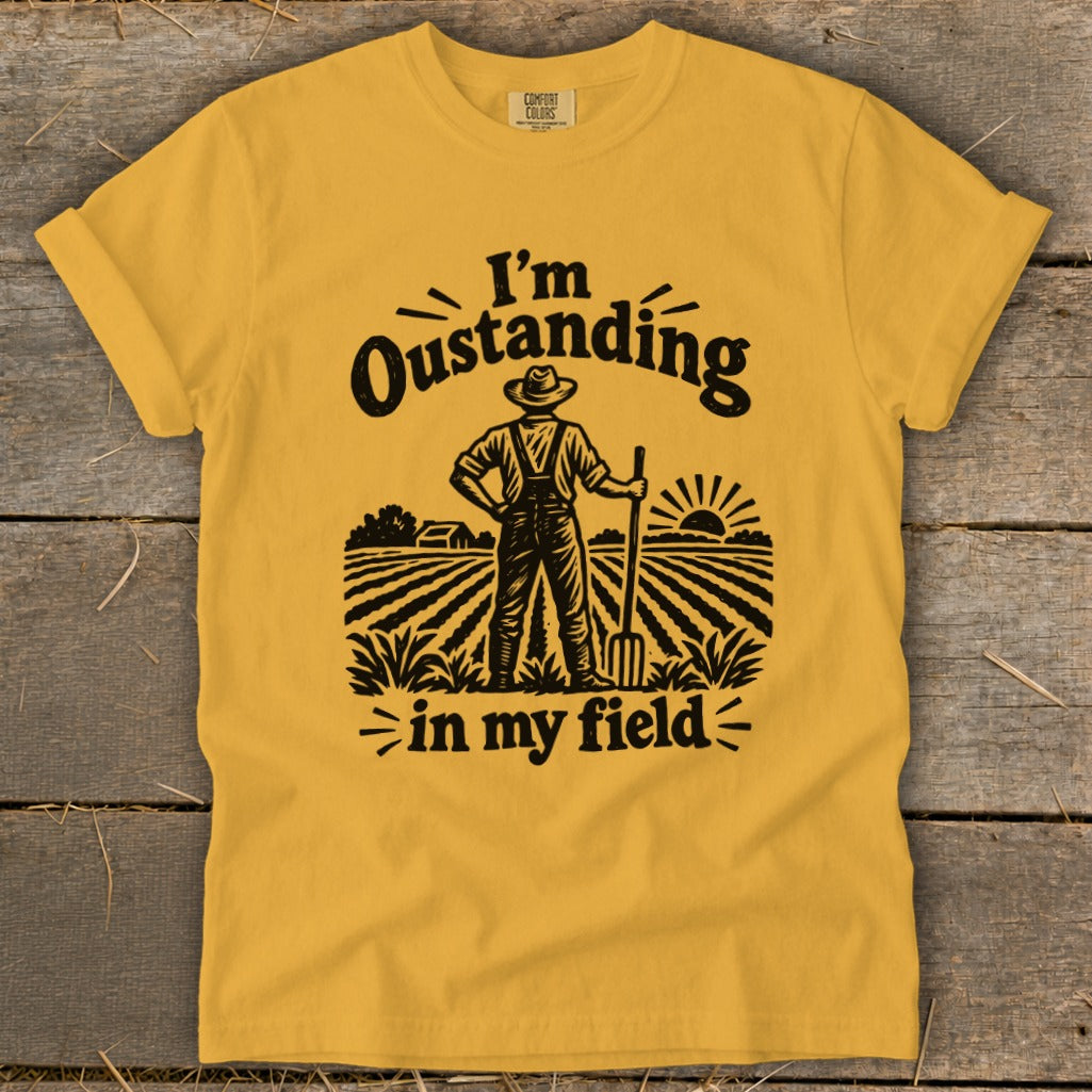 Yellow t-shirt with "I'm Oustanding in my field" graphic and farmer illustration.