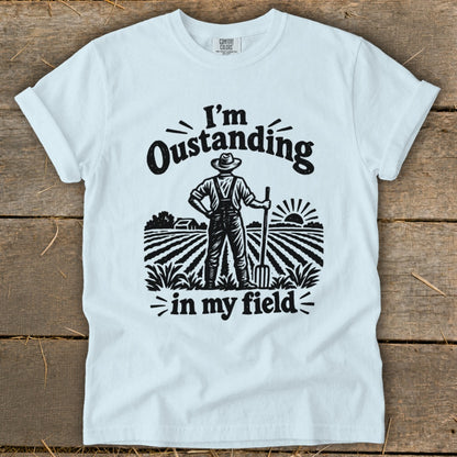 White t-shirt with "I'm Oustanding in my field" graphic of a farmer.