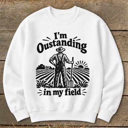 White sweatshirt with graphic "I'm Oustanding in my field" and farmer illustration.