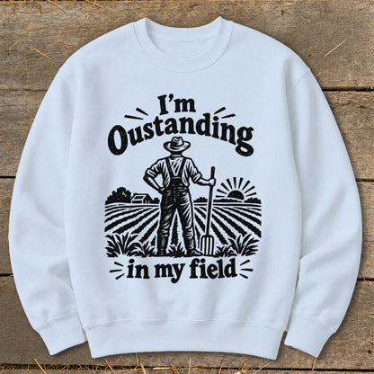 White sweatshirt with black graphic of farmer and text "I'm Oustanding in my field".