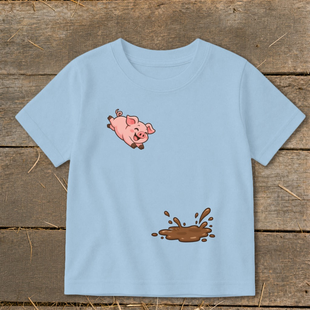 Light blue t-shirt with a cartoon pig leaping above a mud puddle design.