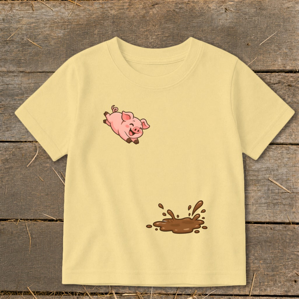 Yellow t-shirt with a cartoon pig jumping into a mud puddle design.