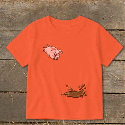 Orange t-shirt with a jumping cartoon pig and a mud splash graphic.