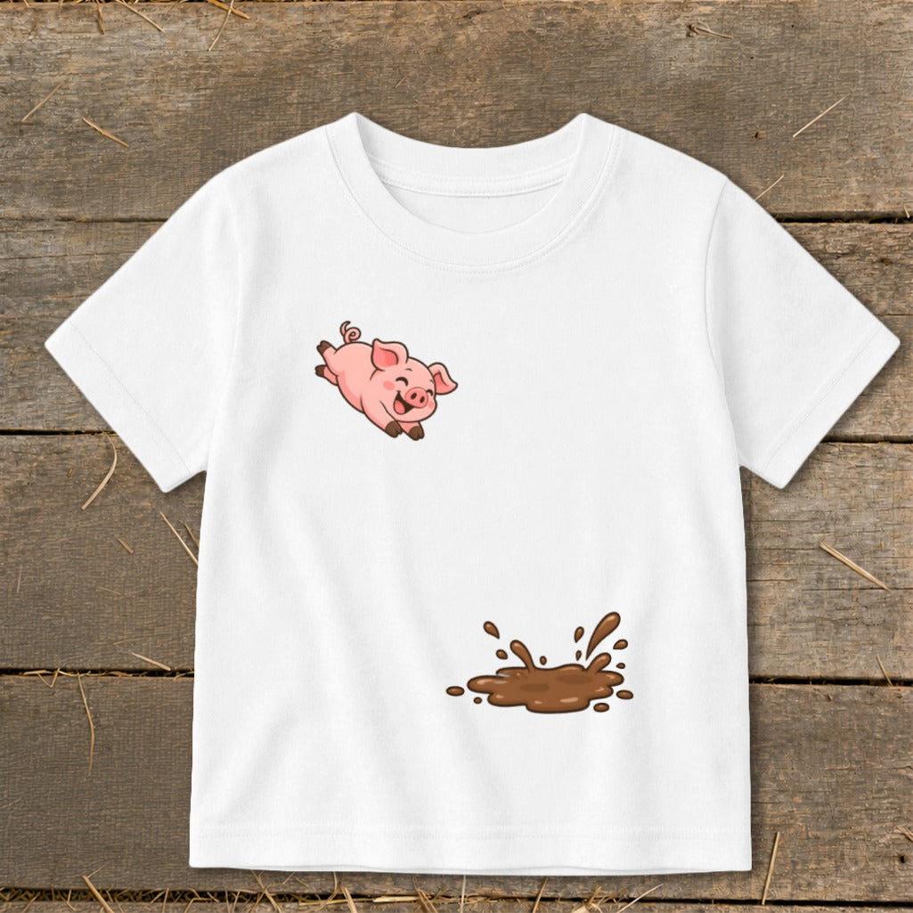 White t-shirt with cartoon pig jumping over a mud splash.
