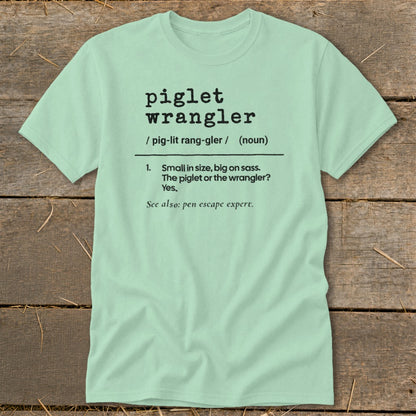 Light green t-shirt with "piglet wrangler" definition printed in black text.