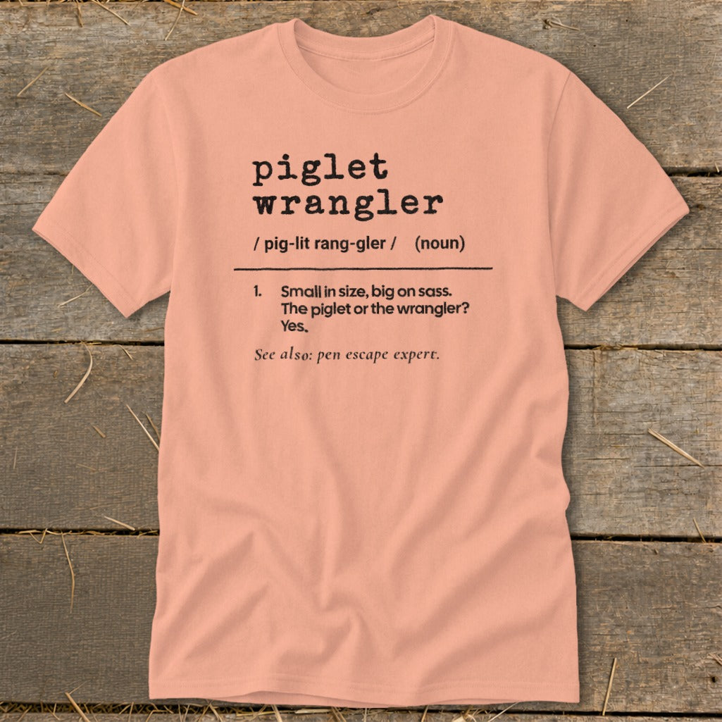 Peach t-shirt with black text defining "piglet wrangler."