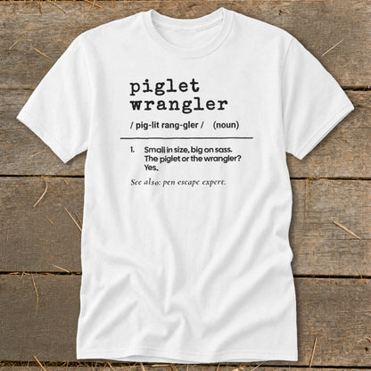 White t-shirt with black text defining "piglet wrangler" and "pen escape expert."
