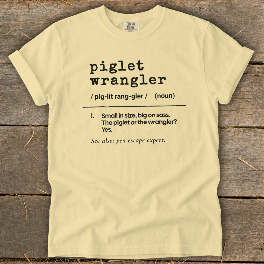 Light yellow t-shirt with "piglet wrangler" definition and "pen escape expert".