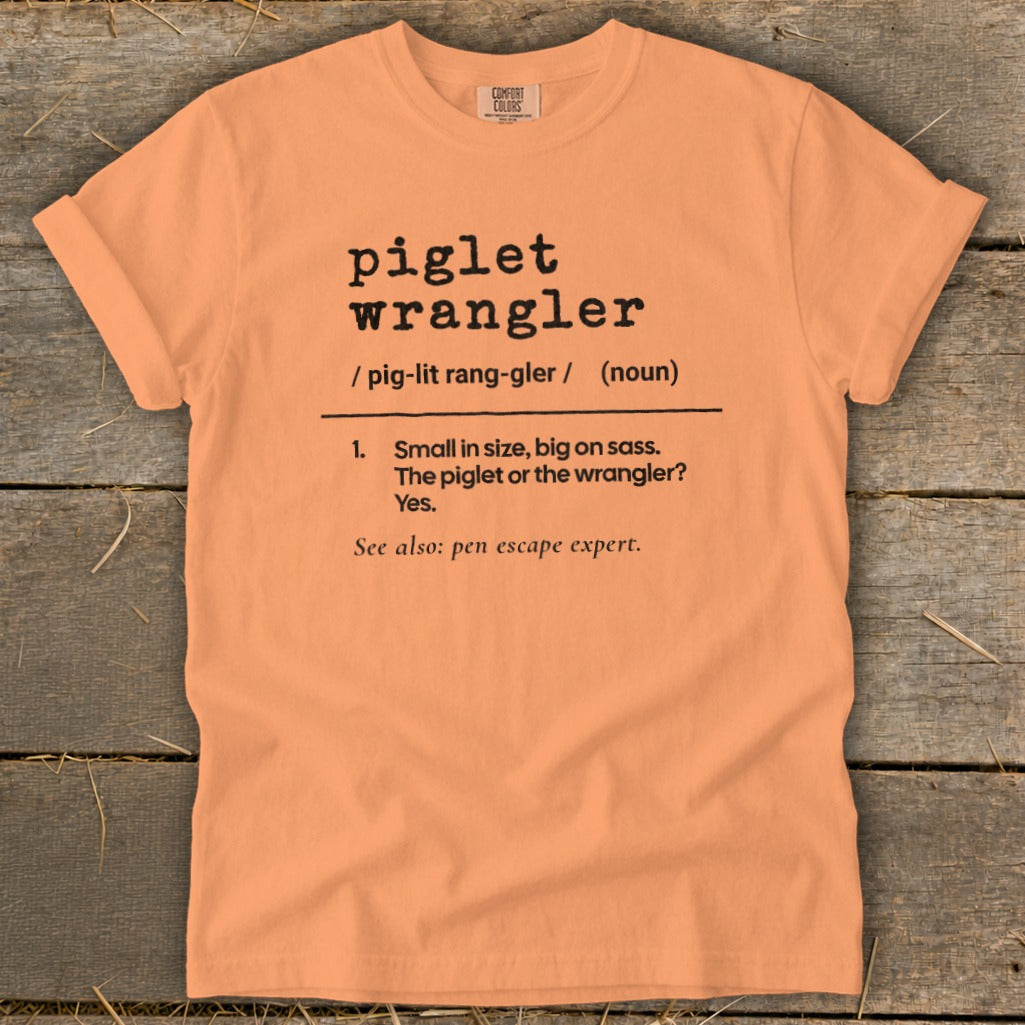 Peach t-shirt with "piglet wrangler" definition: Small, big on sass.