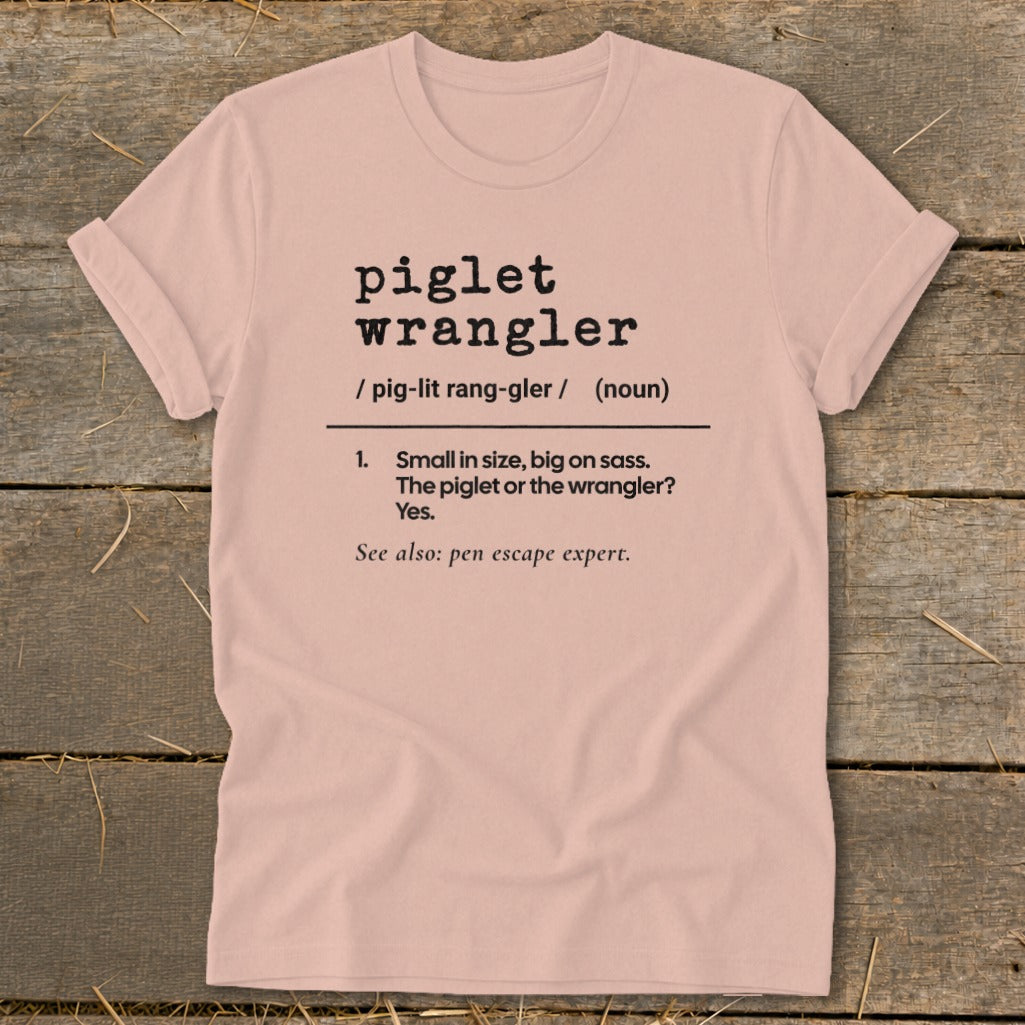 Pink t-shirt with "piglet wrangler" definition and "pen escape expert" text.