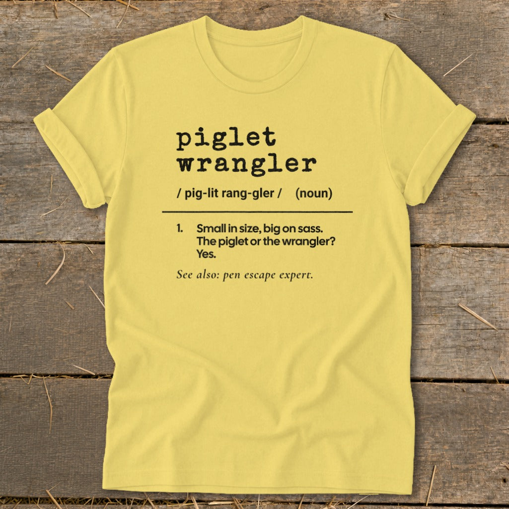 Yellow t-shirt with "piglet wrangler" definition and "pen escape expert."