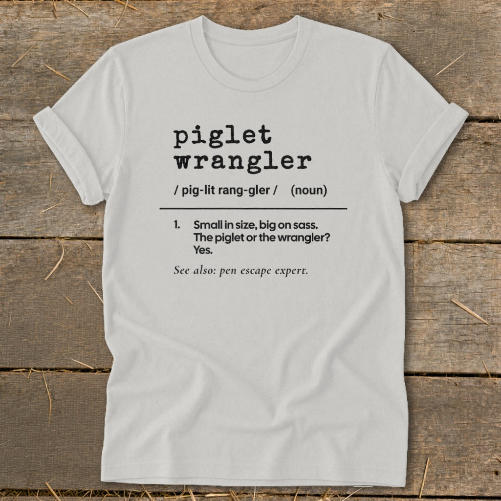 White t-shirt with "piglet wrangler" definition and "pen escape expert".
