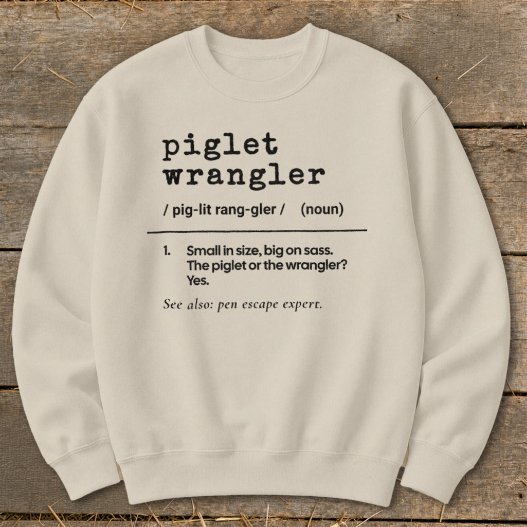 Cream sweatshirt with "piglet wrangler" definition and illustration.