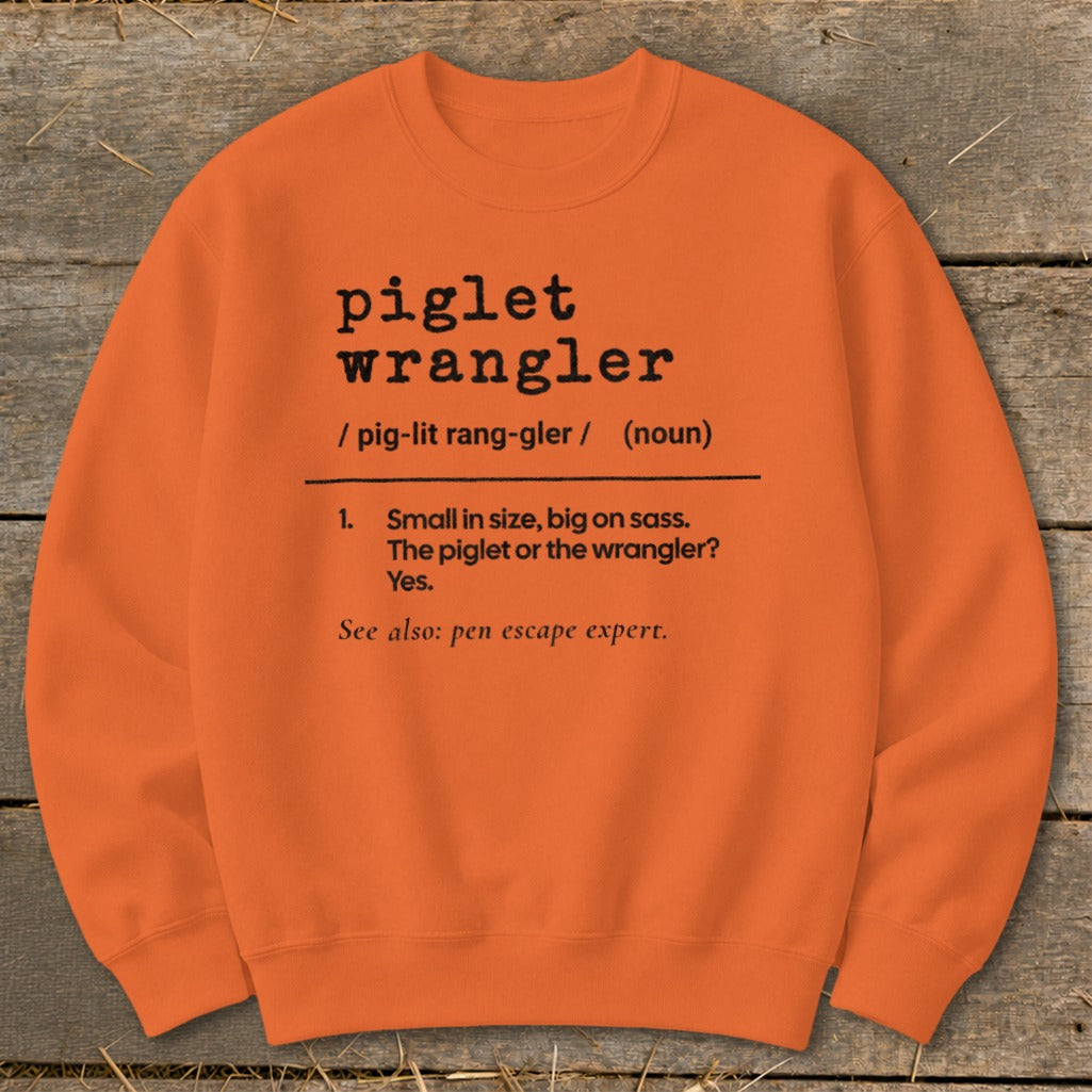 Orange sweatshirt with "piglet wrangler" definition: Small in size, big on sass.