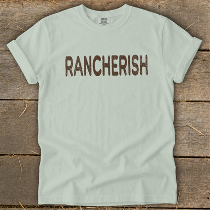 Light mint Comfort Colors t-shirt with brown "RANCHERISH" graphic.