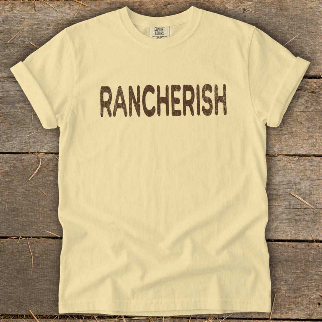 Light yellow Comfort Colors t-shirt with "RANCHERISH" printed in brown text.