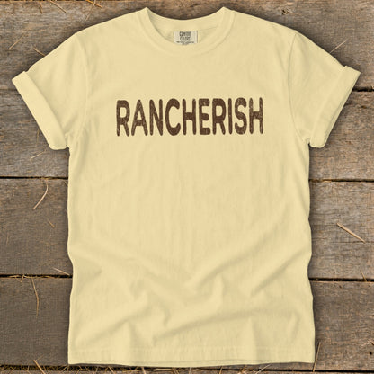 Light yellow Comfort Colors t-shirt with "RANCHERISH" printed in brown text.