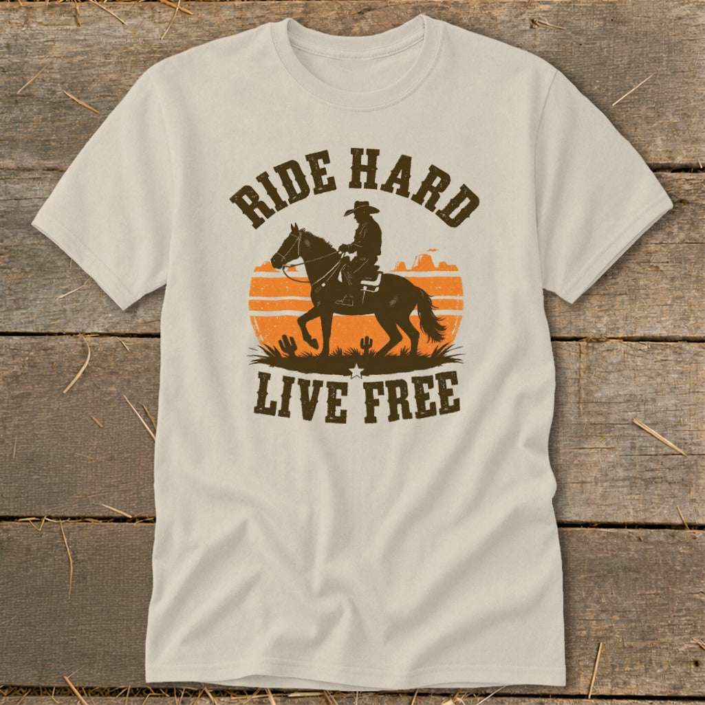 T-shirt graphic with cowboy on horseback, desert sunset, and text "RIDE HARD LIVE FREE".