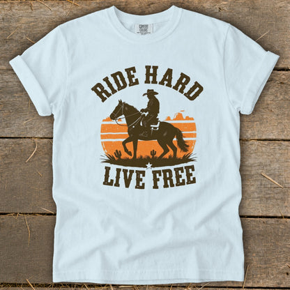 T-shirt with cowboy on horse silhouette, sunset, and text "RIDE HARD LIVE FREE".