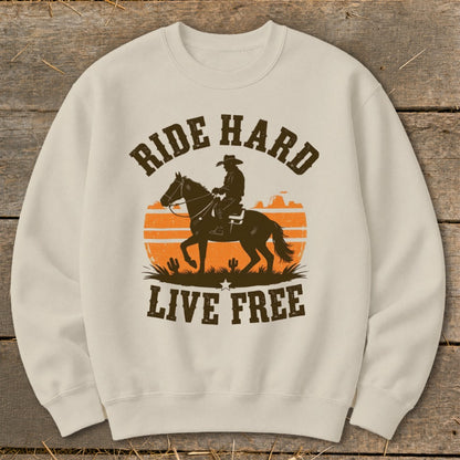 Sweatshirt with a silhouette of a cowboy on a horse, orange sunset, and text "RIDE HARD LIVE FREE."