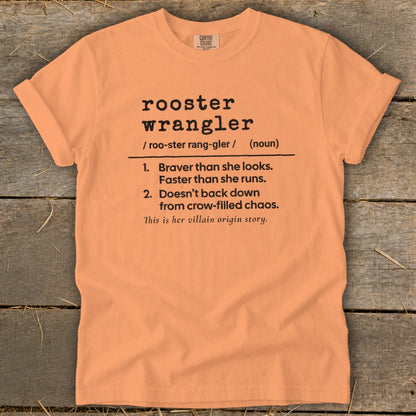 Peach t-shirt with "rooster wrangler" definition: brave, fast, and unflustered.