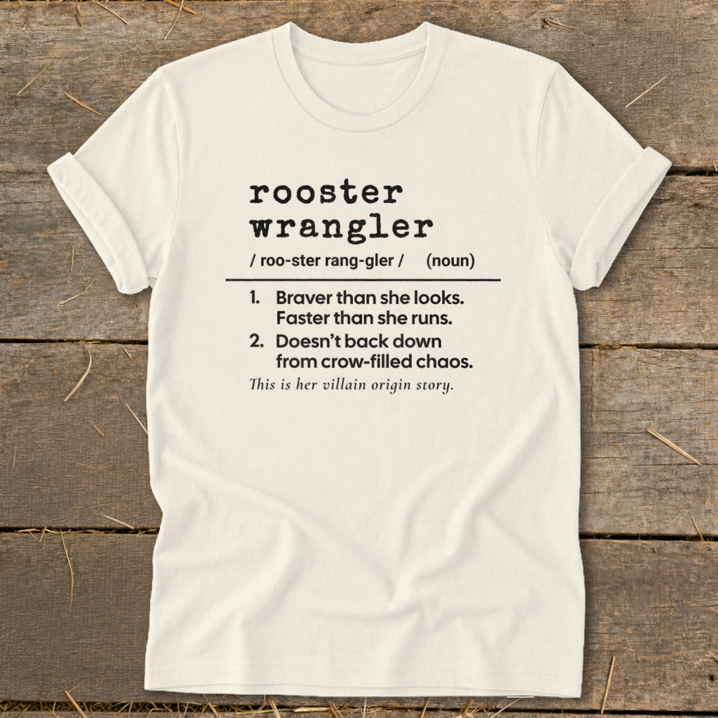 Cream t-shirt with black text defining "rooster wrangler" and its traits.