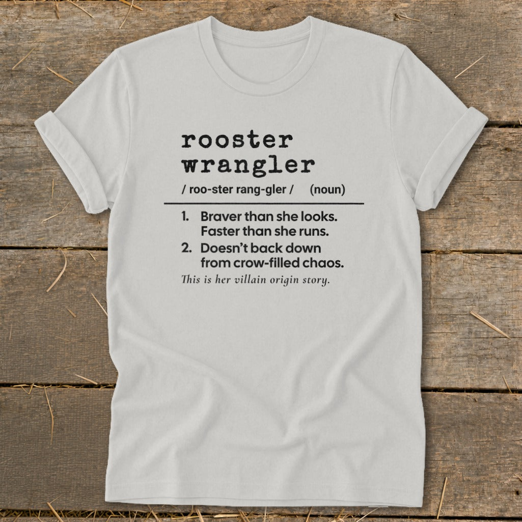 White t-shirt with black text defining "rooster wrangler" as a noun.