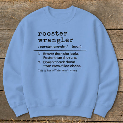 Light blue sweatshirt with "rooster wrangler" definition and "villain origin story" text.