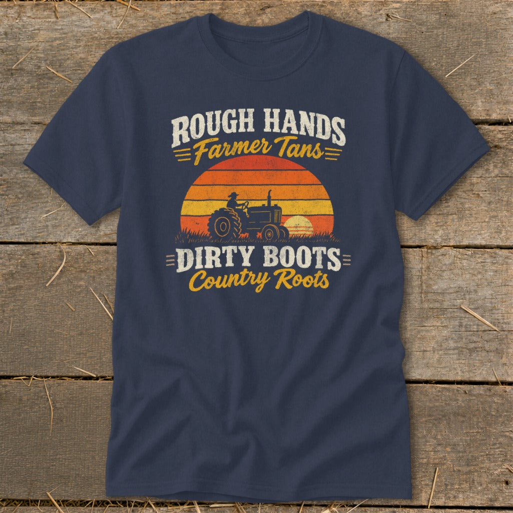 A dark blue t-shirt printed with the text Rough Hands Farmer Tans Dirty Boots Country Roots over a retro tractor and sunset graphic.