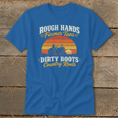 Blue short-sleeve t-shirt featuring a retro graphic of a tractor, sunset, and text reading Rough Hands Farmer Tans Dirty Boots Country Roots.