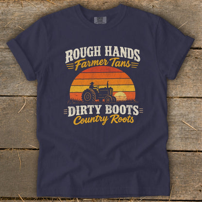 Navy blue t-shirt featuring distressed text reading Rough Hands Farmer Tans Dirty Boots Country Roots over a retro tractor and sunset graphic.