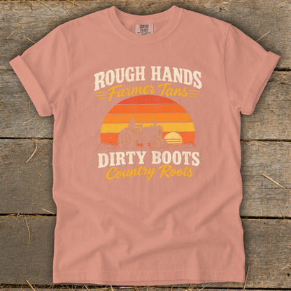 Pink short-sleeve t-shirt with a vintage tractor graphic and the text Rough Hands Farmer Tans Dirty Boots Country Roots.