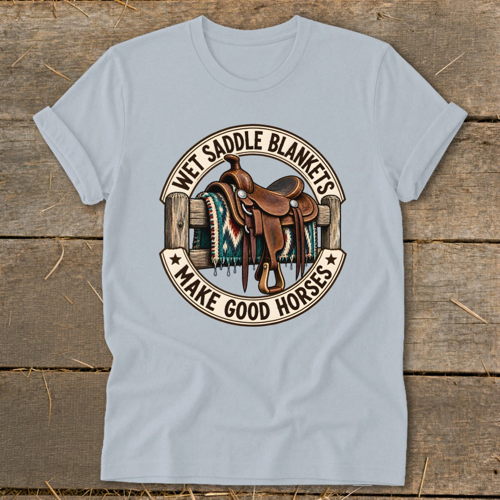 Light blue t-shirt with circular graphic of horse saddle on fence with text "Wet Saddle Blankets Make Good Horses".