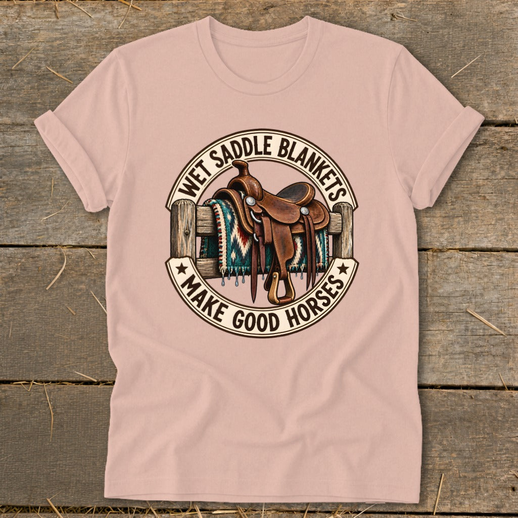 T-shirt with graphic of saddle and blanket on fence, "Wet Saddle Blankets Make Good Horses" text.