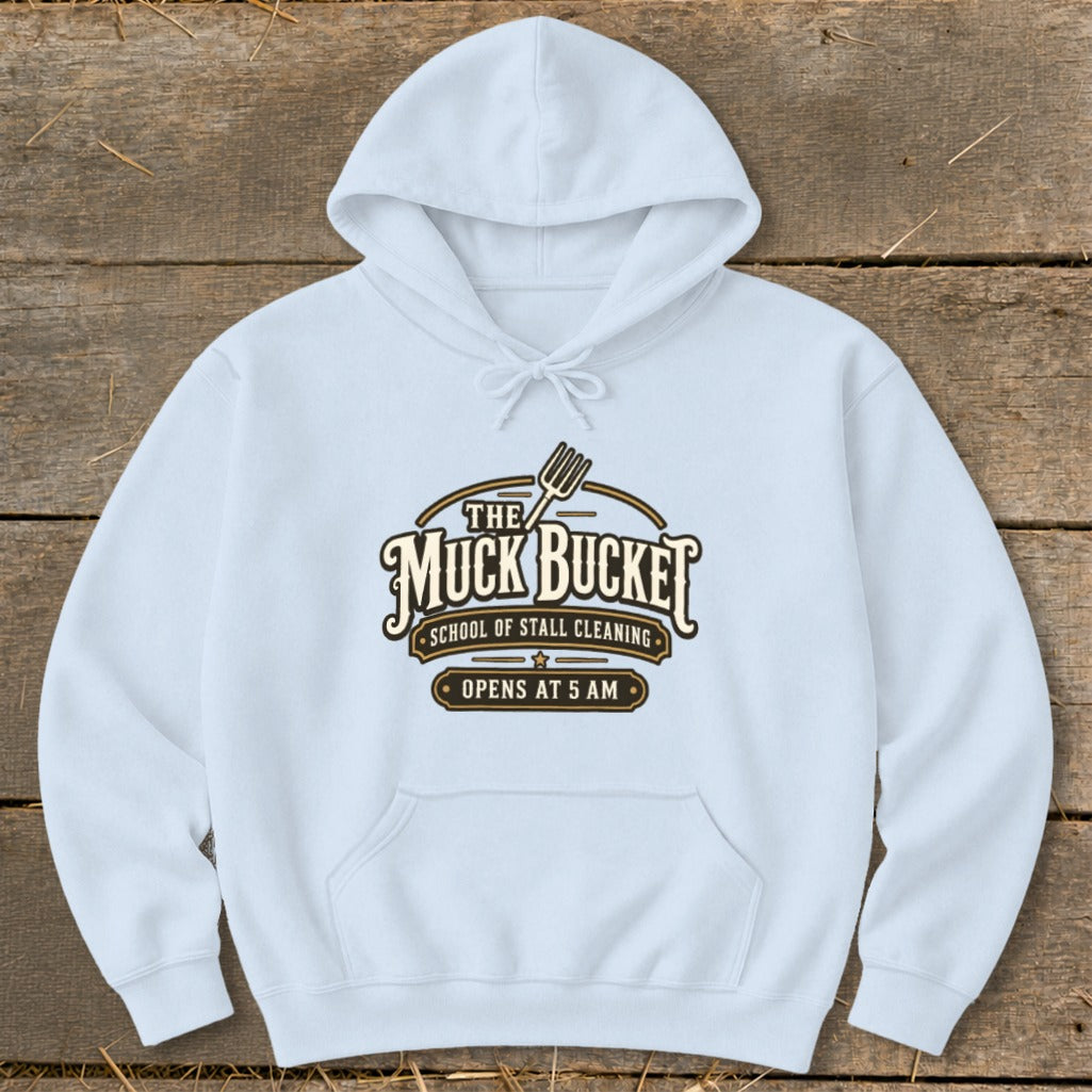 Light blue hoodie with "The Muck Bucket School of Stall Cleaning Opens at 5 AM" logo.