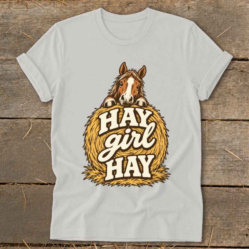 Light gray t-shirt with a brown horse peeking over a hay bale with text.