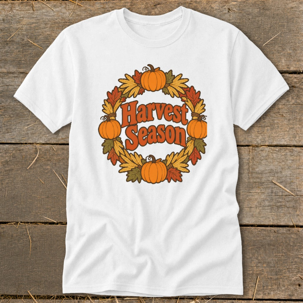 White t-shirt with "Harvest Season" text surrounded by pumpkins and autumn leaves.