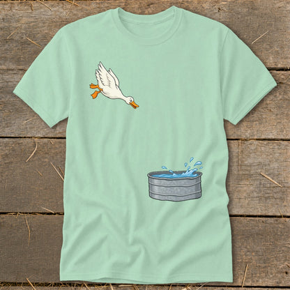 Light blue t-shirt with a cartoon goose jumping towards a galvanized water trough.