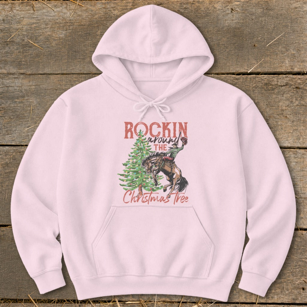Pink hoodie with "Rockin Around The Christmas Tree" graphic featuring a cowboy on a bucking horse.