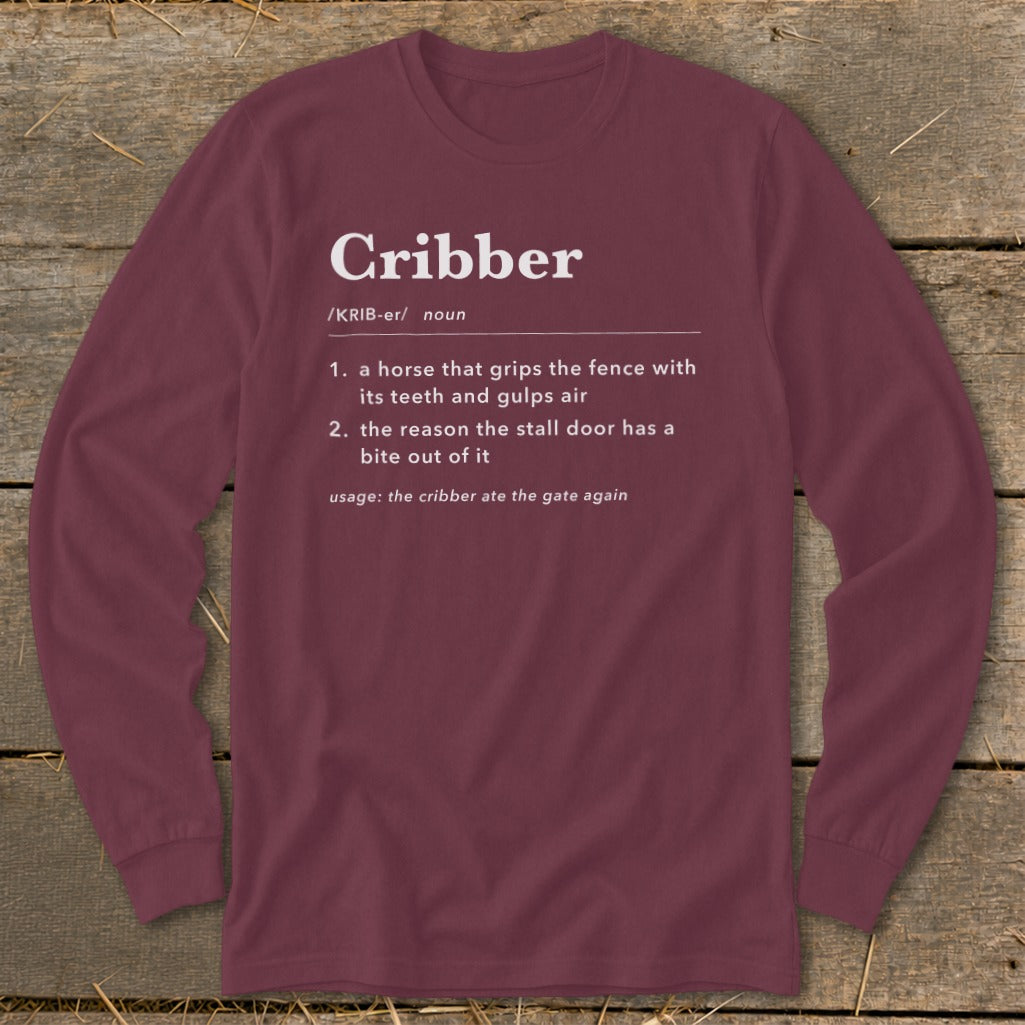 Maroon long-sleeve t-shirt with a humorous dictionary definition of the word "Cribber" printed on the chest.