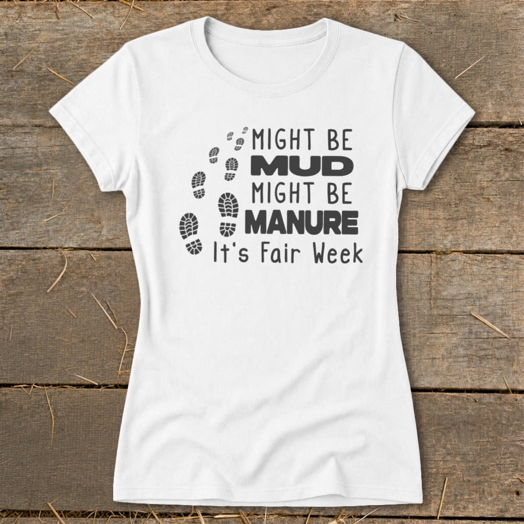 White t-shirt with black text and boot prints: "Might be Mud, Might be Manure. It's Fair Week."