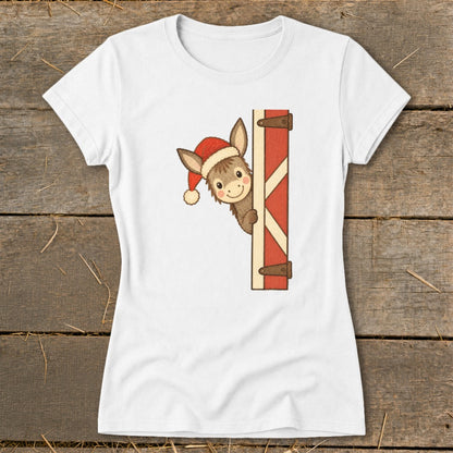 White t-shirt with a cartoon donkey wearing a Santa hat peeking from a barn door.