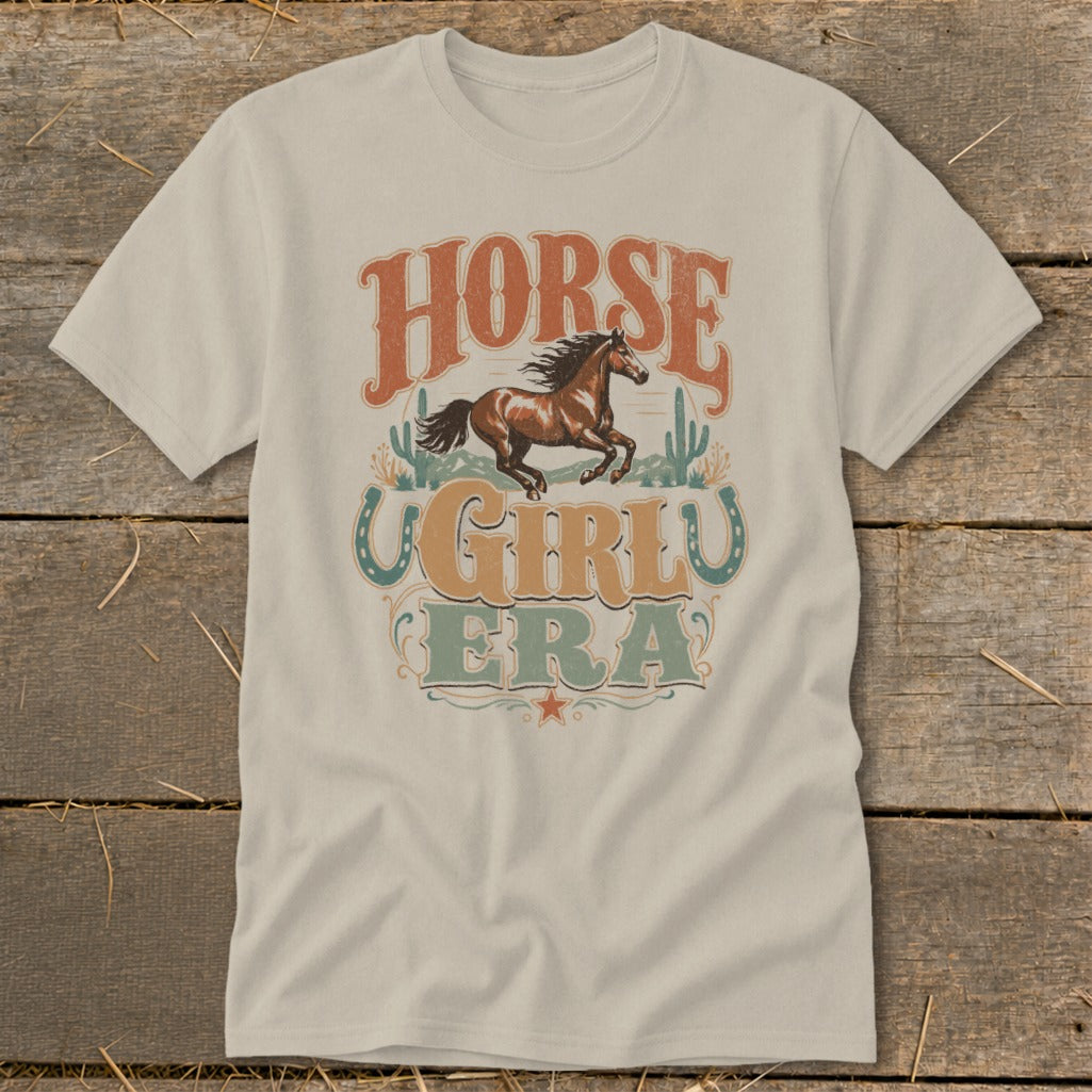 Light tan t-shirt with "HORSE GIRL ERA" graphic featuring a galloping horse and cacti.