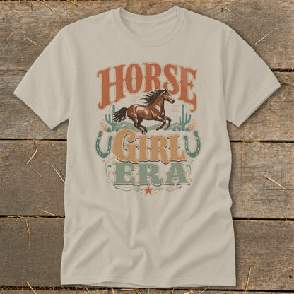 Light tan t-shirt with "HORSE GIRL ERA" graphic featuring a galloping horse and cacti.