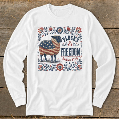 Sheep with American flag fleece, framed by floral border with text "Flocks & Freedom Since 1776".