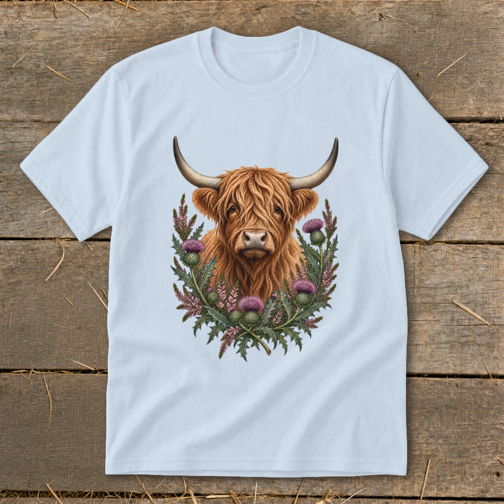 Highland cow illustration with thistles on a light blue t-shirt.