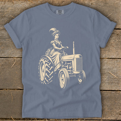 Cream illustration of a woman in a Victorian dress driving a tractor.